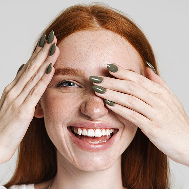 Image of happy ginger girl smiling and covering her eyes
